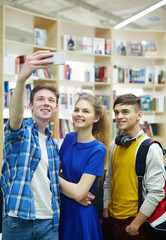 Group of college buddies making selfie in library