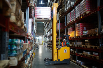 Loader lifting heavy cargo in warehouse