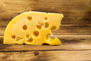 Piece of cheese on the wooden background
