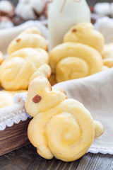 Homemade sweet buns made in bunny shape served with bottle of milk in a wooden box, vertical, closeup