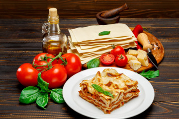 Portion of tasty lasagna on wooden backgound
