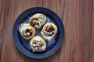 Fresh puff pastry with apple on a blue plate