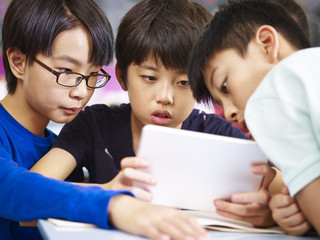 asian elementary schoolboys using tablet together