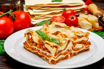 Portion of tasty lasagna on wooden backgound