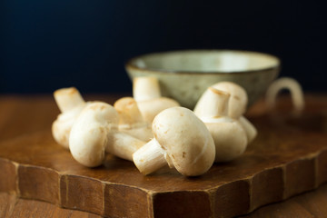 Champignon mushrooms on the wooden table. Selective focus