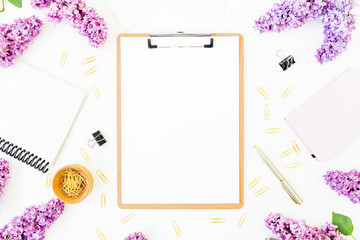 Minimalistic workspace with clipboard, notebook, pen, lilac and accessories on white background. Flat lay, top view. Beauty blog concept. Blogger of freelancer