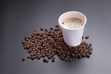 Hot americano coffee in paper cup of coffee and coffee beans on black background