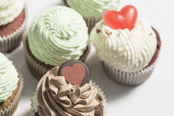 Creamy colorful muffins close up on a white background