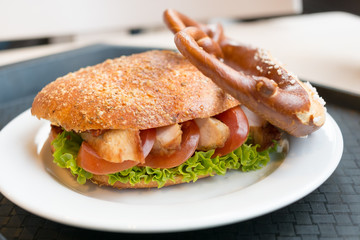 Grilled Chicken Sandwich on Pretzel Bun with Lettuce and Tomato