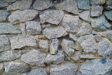 Grungy colorful granite rock wall with cement background
