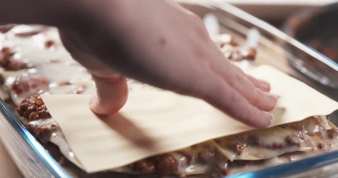 Slide shot of preparing traditional italian lasagna adding pasta, 4k 60fps prores footage