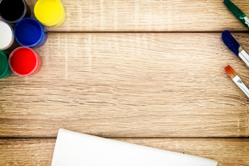 Farbdosen mit Pinsel und Leinwand auf Holz Untergrund