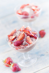Sweet dessert from cheese and yogurt with fresh ripe strawberry in a glass jar, on rustic wooden background. Selective focus