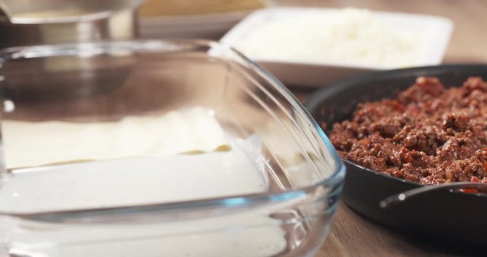 Slide shot of preparing traditional italian lasagna adding pasta, 4k 60fps prores footage