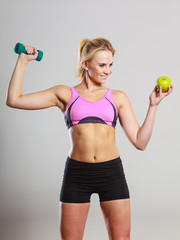 Diet fit body. Girl holds dumbbells and apple fruit