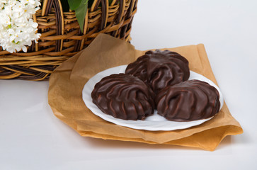 marshmallow with chocolate on a white plate and crumpled paper