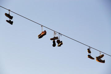 Shoes dangling on a electric cable over the street