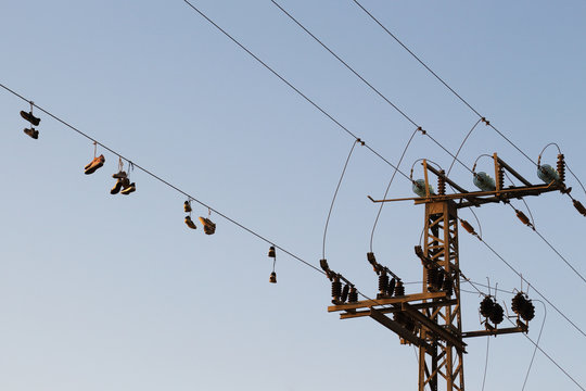 Shoes dangling on a electric cable over the street