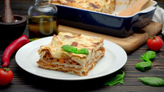 Portion of tasty lasagna on wooden backgound