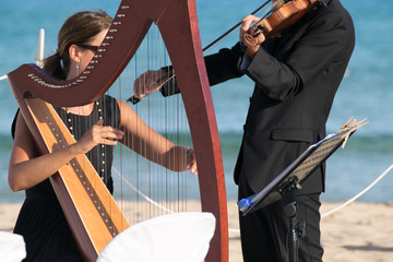 Harp and violin concert at the seaside for the  wedding day.
