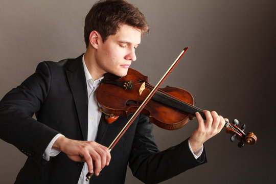 Man man dressed elegantly playing violin