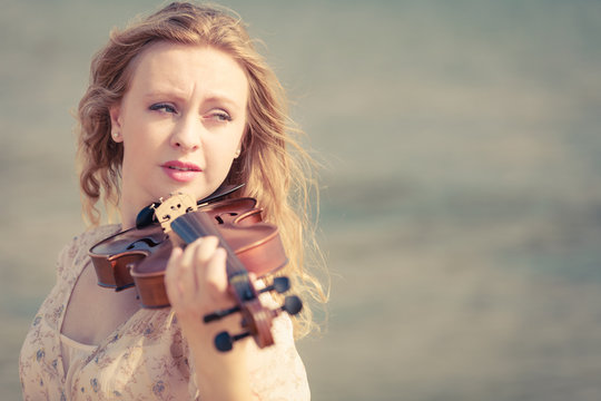 Woman playing violin on violin near beach