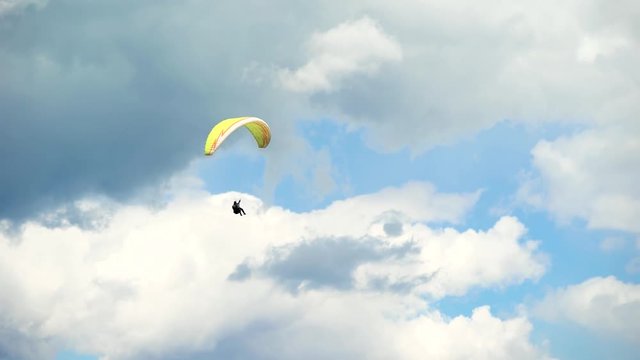 The paraglider in the sky, flies in the air streams. An extreme hobby for wealthy men. Modern equipment