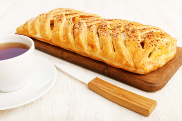 Homemade puff braided pie with cottage cheese, apples and raisin