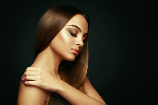 Beauty Portrait Of A Young Woman With Long Straight Hair And Beautiful Makeup In The Studio On A Dark Background