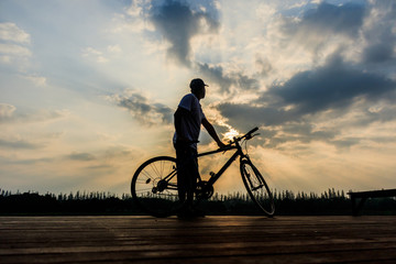 silhouette of man at lake sunset time after intense cycling training,