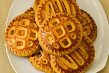 Fresh homemade cookies with dried apricots and cottage cheese on a white plate.