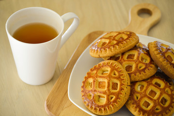 Morning tea with biscuits. On a light wooden table