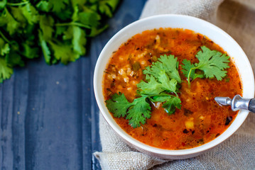 Georgian soup kharcho with lavash. National dish of Georgian harcho. Soup kharcho with cilantro and vegetables on a wooden table.