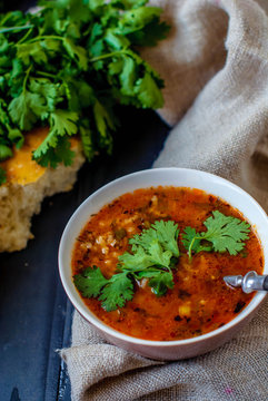 Georgian soup kharcho with lavash. National dish of Georgian harcho. Soup kharcho with cilantro and vegetables on a wooden table.