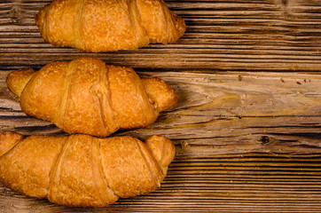 Fresh croissants on wooden table. Top view