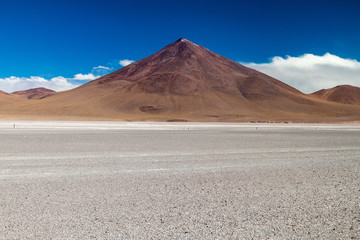 Borax deposits at Laguna Colorada lake with mountain peaks in the background, Bolivia