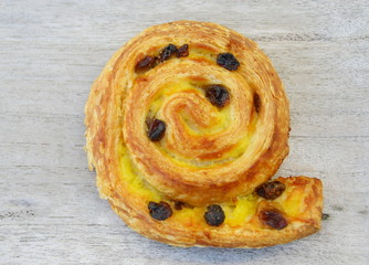 pain aux raisins, isolé sur fond bois,viennoiserie