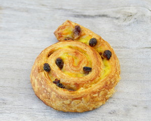 pain aux raisins, isolé sur fond bois,viennoiserie