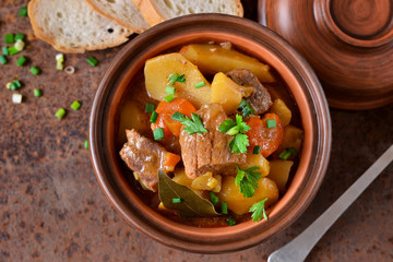 Stew with vegetables and potatoes on an old grunge background