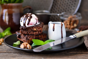 Homemade chocolate brownies with nuts, chocolate sauce and mint
