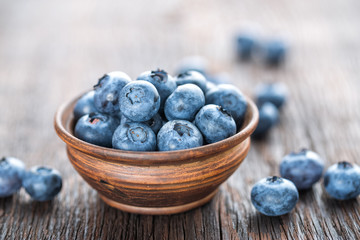 Fresh Blueberry in bowl on wooden background, closeup