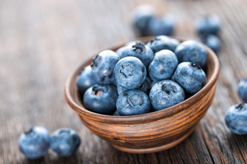 Fresh Blueberry in bowl on wooden background, closeup