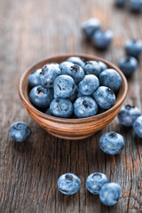 Fresh Blueberry in bowl on wooden background, closeup