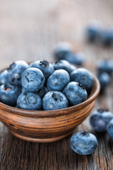 Fresh Blueberry in bowl on wooden background, closeup