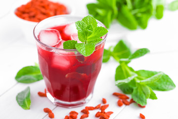 Healthy detox drink with goji berries infused in water with ice, cold refreshing beverage