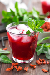 Healthy detox drink with goji berries infused in water with ice, cold refreshing beverage