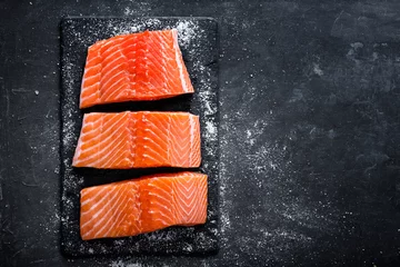 Gordijnen Raw salmon filet on dark slate background, wild atlantic fish © Sea Wave