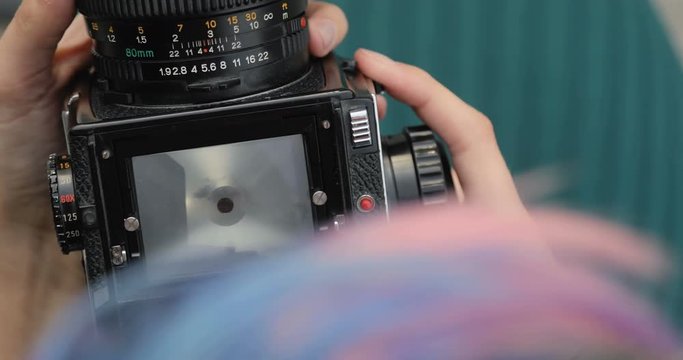 Old medium format camera in the hands of a hipster girl, close-up, film camera