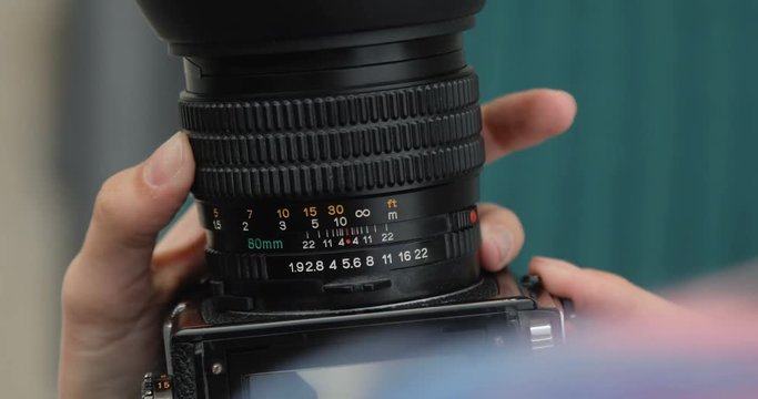 Old medium format camera in the hands of a hipster girl, close-up, film camera