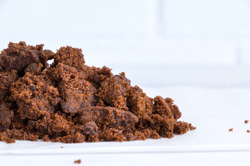 Heap of muscovado - brown natural sugar. Selective focus. Corner location. Closeup. Copy space.